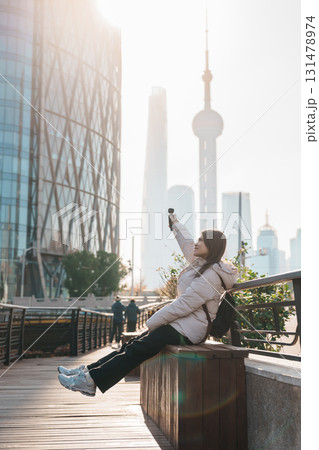 woman traveler visiting in Shanghai, China. Female Tourist with backpack sightseeing Shanghai view of Lujiazui in Hongkou Gang canal of Shanghai. landmark and popular for tourism attraction woman traveler visiting in Shanghai, China. Female Tourist with backpack sightseeing Shanghai view of Lujiazui in Hongkou Gang canal of Shanghai. landmark and popular for tourism attraction 131478974