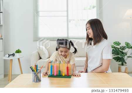 Engaging Learning Environment with a Young Girl and an Adult Woman Interacting with Colorful Counting Tool Engaging Learning Environment with a Young Girl and an Adult Woman Interacting with Colorful Counting Tool 131479493