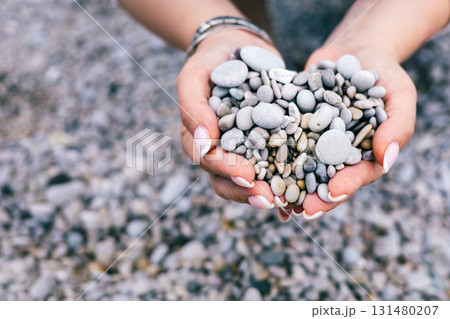 Heart-Shaped Pebbles in Female Hands on Rocky Beach Representing Love, Nature and Calm 131480207