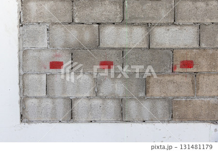 Worker is marking lebel for electrical outlets and wall switches location on new kitchen wall. 131481179