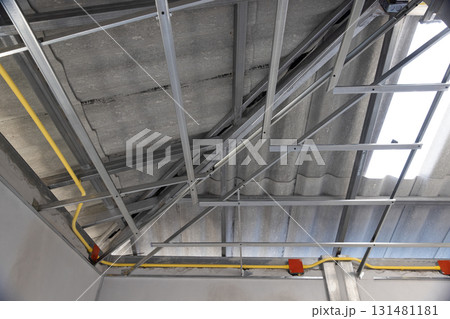 Worker is installing  metal profiles for gypsum board ceiling in renovate house. 131481181