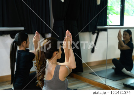 Yoga instructor and student meditating and focusing on breathing exercises 131481574