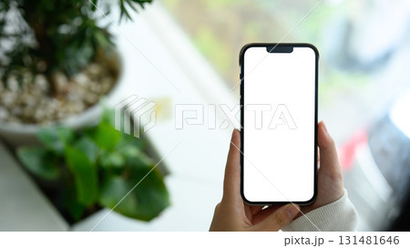 Hands holding a smartphone with blank white screen, ready for app mockup or design presentation 131481646