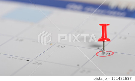 Red push pin marking the 20th on a calendar, symbolizing an important appointment or event reminder Red push pin marking the 20th on a calendar, symbolizing an important appointment or event reminder 131481657