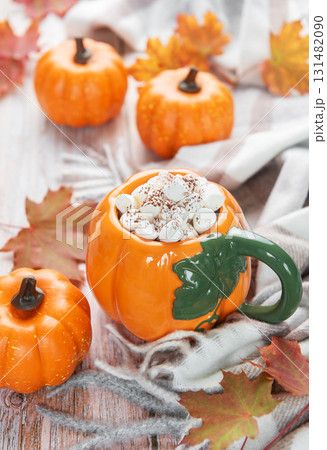 Pumpkin mug of hot chocolate with autumn leaves 131482090