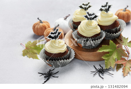 Halloween cupcakes with bats, pumpkins, and autumn leaves 131482094