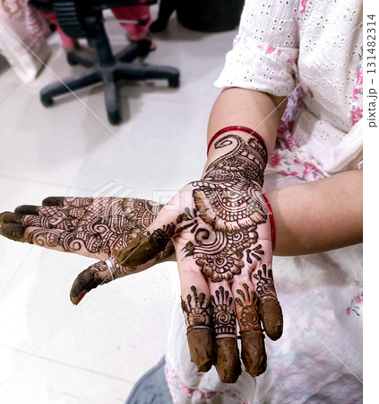 Picture of human hand being decorated with henna tattoo,Decorated Mehendi cone in Indian wedding ceremony Picture of human hand being decorated with henna tattoo,Decorated Mehendi cone in Indian wedding ceremony 131482314
