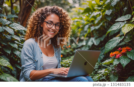 Blue house with a white picket fence and a garden in front of it. The house is surrounded by trees and flowers 131483135
