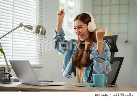 Successful business woman, excited young woman Keeping up arms and showing positive emotions, happy working in modern office on laptop computer. Successful business woman, excited young woman Keeping up arms and showing positive emotions, happy working in modern office on laptop computer. 131483183