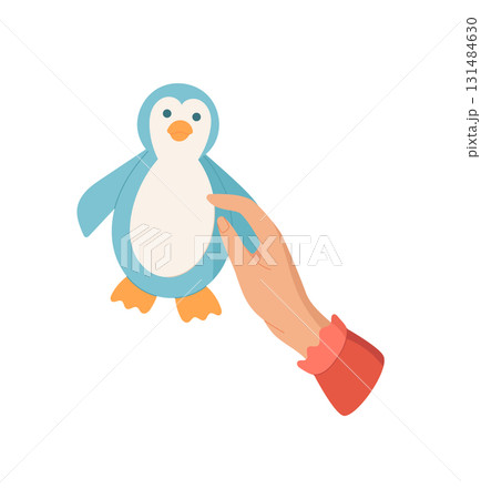 Hand holds a cute penguin toy in a colorful cartoon graphic style. The image captures the joy of craft and DIY activities for children. Concept of creativity, playfulness, and artistic expression. 131484630