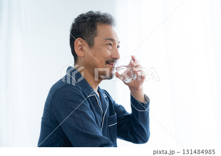 寝室で水を飲むミドルの男性 131484985