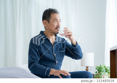 寝室で水を飲むミドルの男性 寝室で水を飲むミドルの男性 131485019