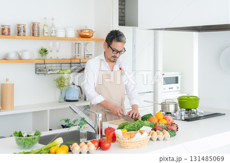 キッチンで料理を作るミドルの男性 131485069