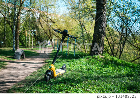 Yellow scooter in the park on the lawn 131485325