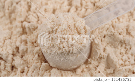 Scoop filled with vanilla protein powder. Macro close-up of sports nutrition supplement for fitness, healthy diet and muscle recovery concept. White protein, whey powder. Bodybuilding gym lifestyle Scoop filled with vanilla protein powder. Macro close-up of sports nutrition supplement for fitness, healthy diet and muscle recovery concept. White protein, whey powder. Bodybuilding gym lifestyle 131486753