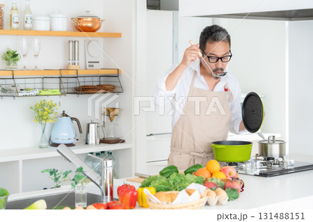 キッチンで料理を作るミドルの男性 キッチンで料理を作るミドルの男性 131488151