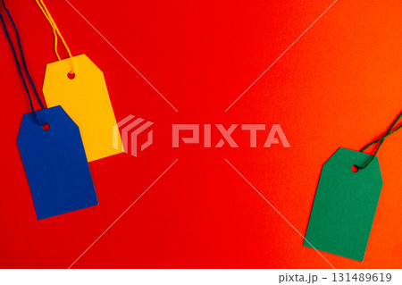 Blue yellow green price tags on red background with copy space Blue yellow green price tags on red background with copy space 131489619