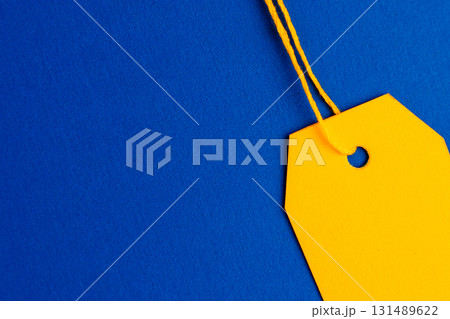 Close up yellow price tag on blue background with copy space Close up yellow price tag on blue background with copy space 131489622