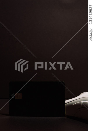 Minimal black contactless card and white gaming mouse in low key light Minimal black contactless card and white gaming mouse in low key light 131489627
