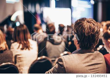 Speaker giving a talk in conference hall at business event. Rear view of unrecognizable people in audience at the conference hall. Business and entrepreneurship concept Speaker giving a talk in conference hall at business event. Rear view of unrecognizable people in audience at the conference hall. Business and entrepreneurship concept 131493451