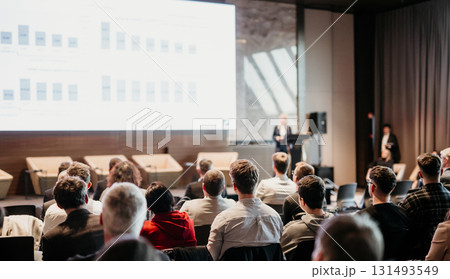 Female speaker giving a talk on corporate business conference. Unrecognizable people in audience at conference hall. Business and Entrepreneurship event 131493549