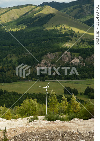 Small wind turbine generating clean, renewable energy in lush green valley with rolling hills and verdant forest. Small wind turbine generating clean, renewable energy in lush green valley with rolling hills and verdant forest. 131493701