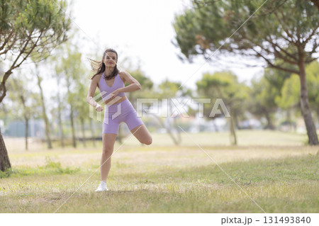 Young woman exercising outdoors performing a fitness routine 131493840