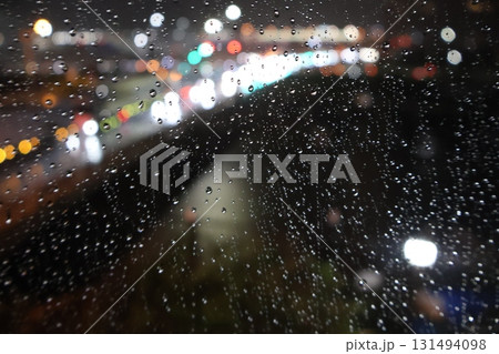 窓に雨粒つき外はネオンが光る夜の街の風景 窓に雨粒つき外はネオンが光る夜の街の風景 131494098