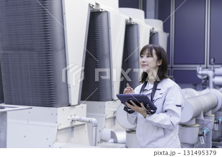 ビルの屋上で点検作業をする若い女性作業員　撮影協力：学校法人電波学園 東京電子専門学校 131495379