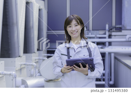 タブレットを持つ笑顔の若い女性作業員　撮影協力：学校法人電波学園 東京電子専門学校 131495380