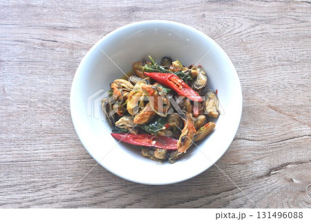 spicy stir fried mussel with chili and basil leaf in curry sauce on bowl spicy stir fried mussel with chili and basil leaf in curry sauce on bowl 131496088