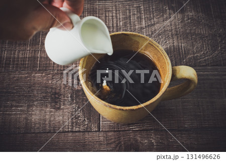コーヒーにミルクを注ぐ コーヒーにミルクを注ぐ 131496626
