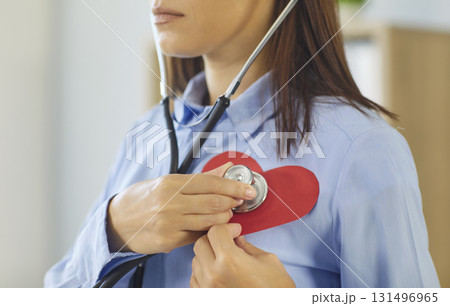 Cardiologist using stethoscope on paper heart symbolizing cardiology health care concept Cardiologist using stethoscope on paper heart symbolizing cardiology health care concept 131496965