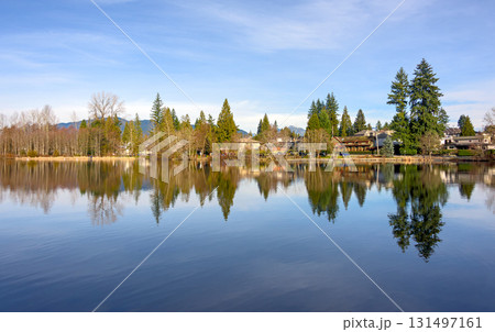 Winter cityscape and a park on a lake shore with reflection in the water Winter cityscape and a park on a lake shore with reflection in the water 131497161