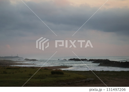 海岸と潮しぶきの波打ち際とテトラポットの波除のある海と雲の多い夕空の風景 海岸と潮しぶきの波打ち際とテトラポットの波除のある海と雲の多い夕空の風景 131497206