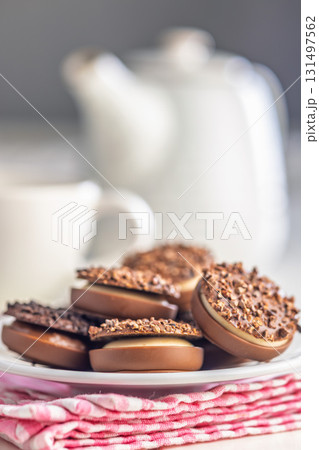 Sweet chocolate pralines. Chocolate candies on plate on checkered napkin. 131497562