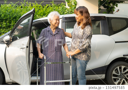 Caregiver help Asian elderly woman disability patient get in her car. Caregiver help Asian elderly woman disability patient get in her car. 131497585