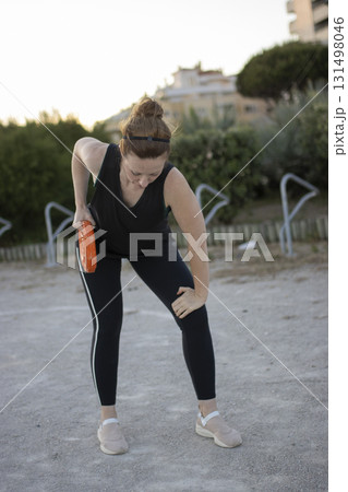Woman experiencing knee pain during outdoor workout Woman experiencing knee pain during outdoor workout 131498046