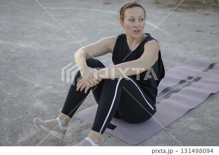 Woman resting on yoga mat after training 131498094