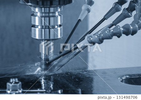 The CNC milling machine rough cutting the mold parts with oil coolant method in the light blue scene 131498706