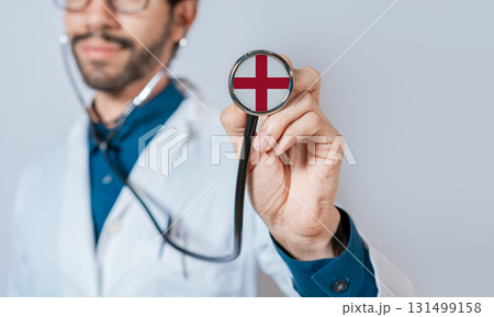 Doctor holding stethoscope with England flag. England health and care concept. England flag on stethoscope 131499158