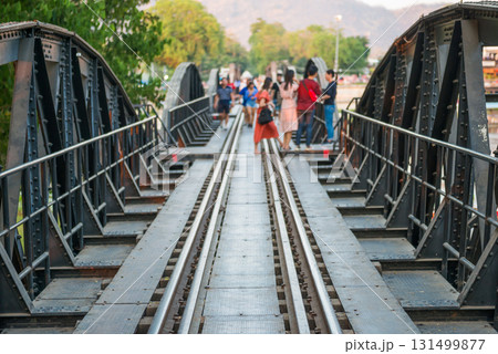People walking by rail track of railroad bridge 131499877