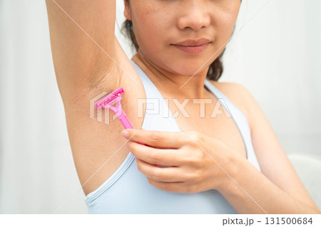 Asian young woman shaving armpit hair clean removal with razor after shower. 131500684