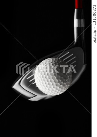 Golf ball positioned before driver strike against black background close-up Golf ball positioned before driver strike against black background close-up 131500873