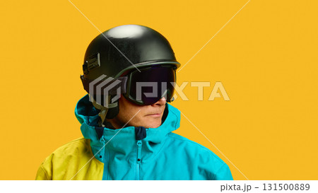Skier close-up portrait in helmet and goggles against yellow background Skier close-up portrait in helmet and goggles against yellow background 131500889