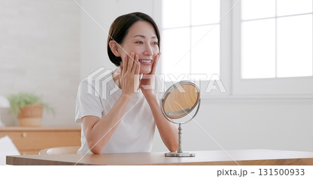 鏡を見ながらスキンケアをするミドル女性 131500933