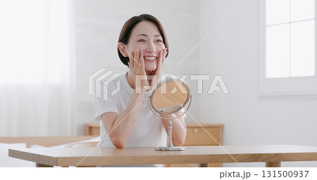 鏡を見ながらスキンケアをするミドル女性 131500937