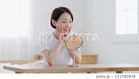 鏡を見ながらスキンケアをするミドル女性 131500938