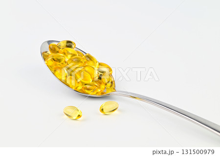 A spoonful of fish oil capsules are shown on a white background 131500979