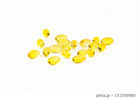 A bunch of yellow pills are scattered on a white background A bunch of yellow pills are scattered on a white background 131500980